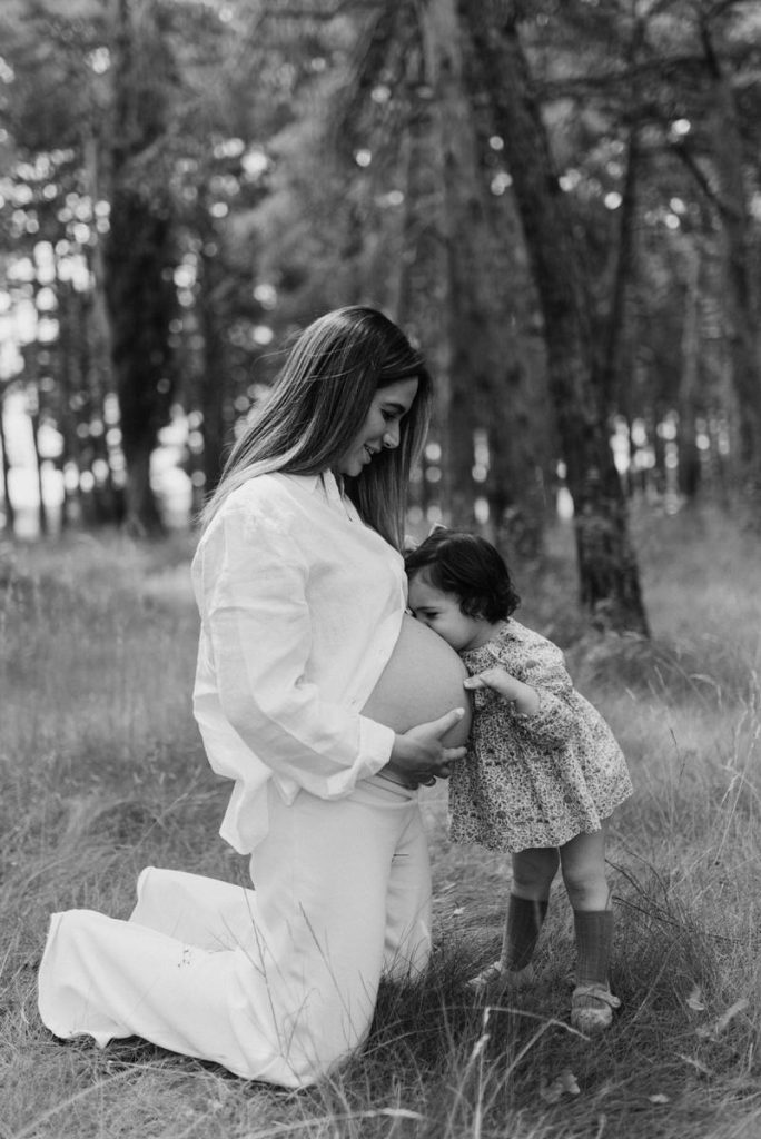 Una niña besa la tripa de su madre embarazada en un reportaje de maternidad